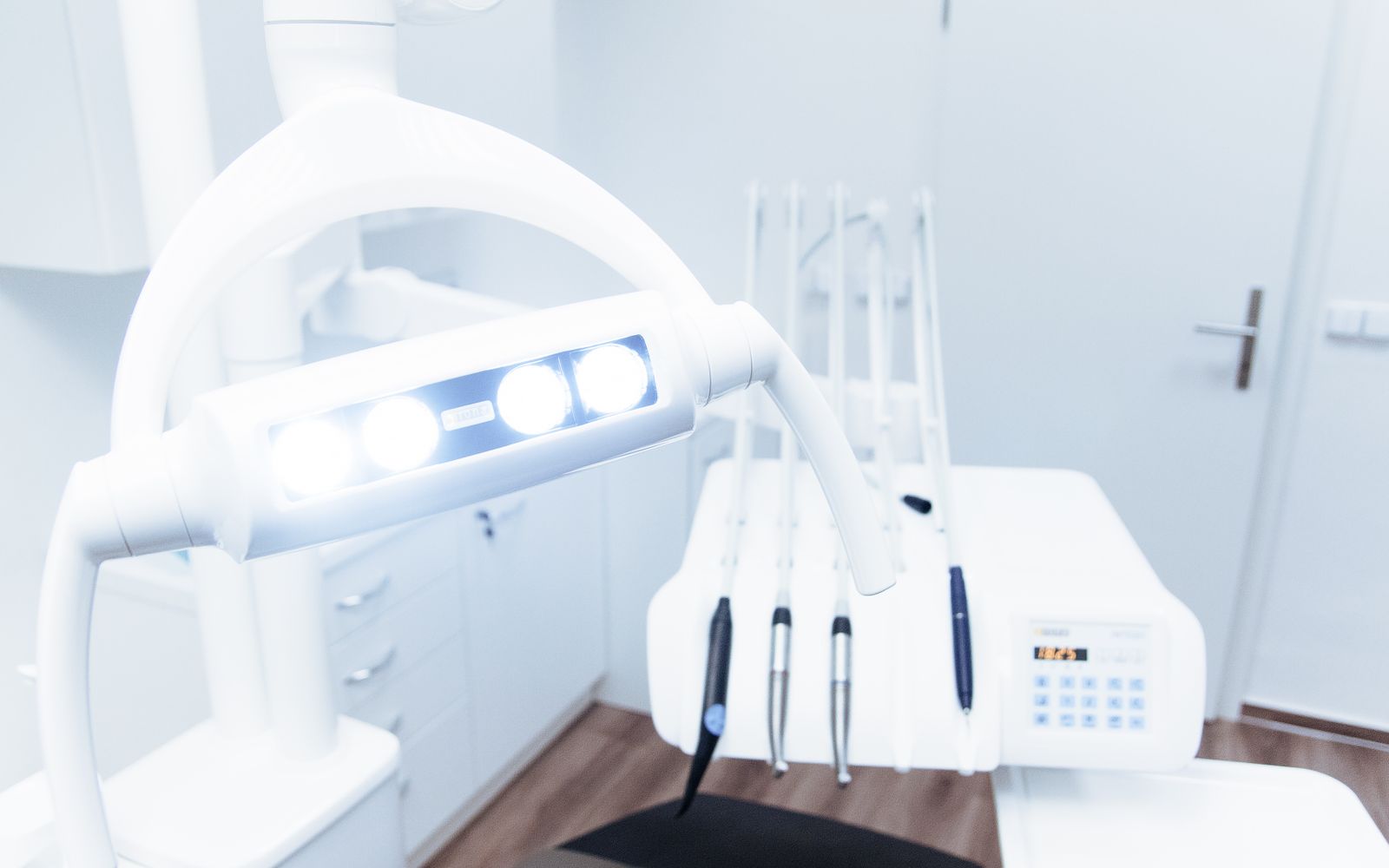 Treatment room with dental chair, overhead light, and monitor